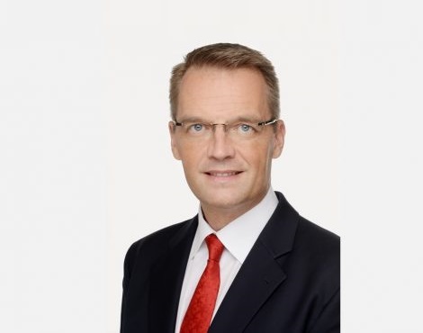 Hans Henrik Christensen vice president of Dtec, wearing a black suit, white shirt and red tye, smiling